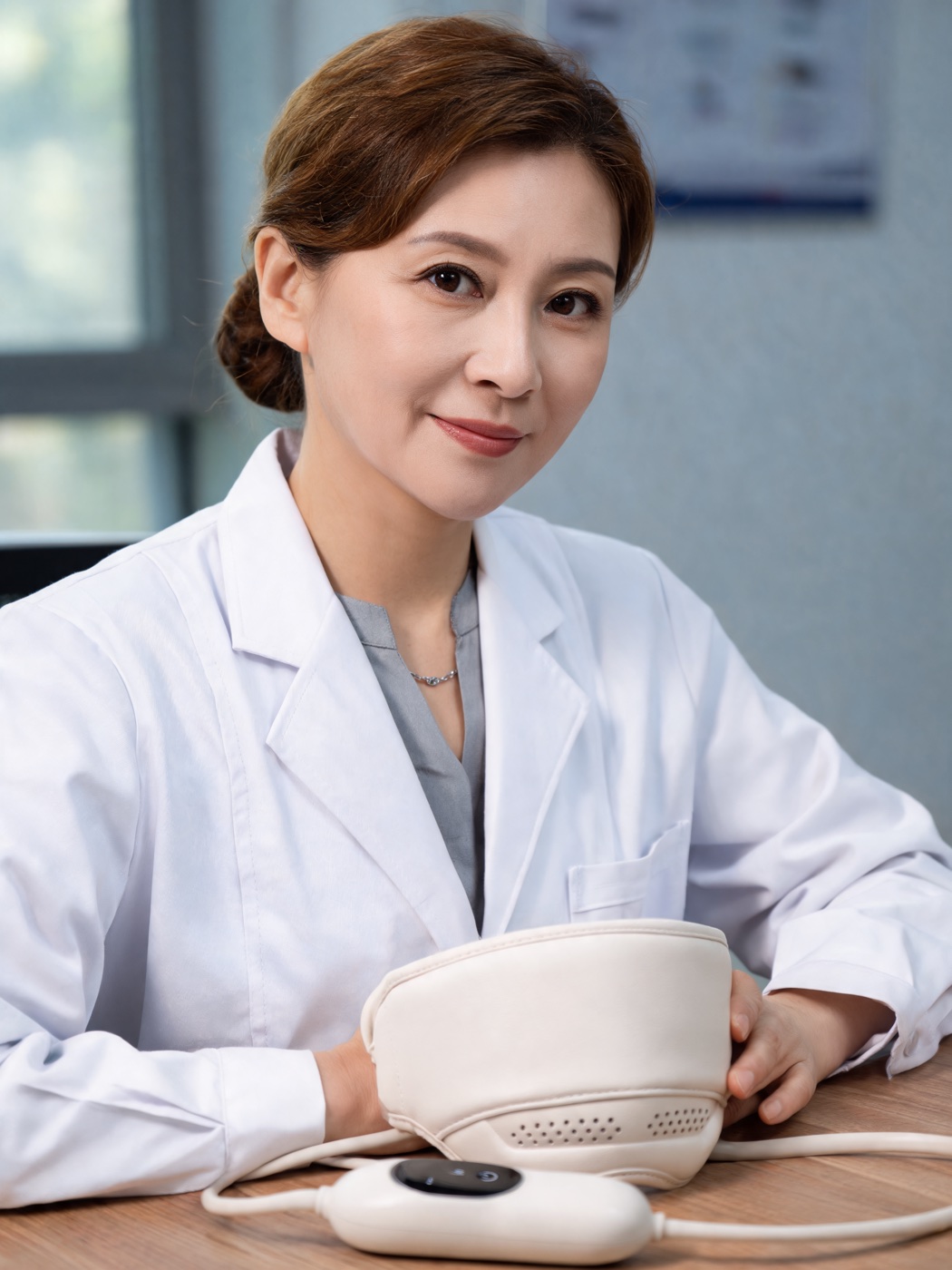A consultant neurologist seated at her desk with Kalmely placed beside her